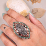 Victorian marquise black diamond ring with an emerald halo in a sterling silver cocktail setting.