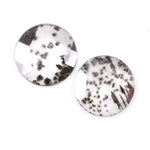 Two round brilliant cut lab grown diamonds with black galaxy-style inclusions on white background, faceted loose stones for custom fine jewelry.