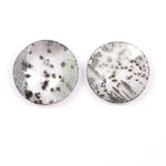 Two round brilliant cut lab grown diamonds with black galaxy-style inclusions on white background, faceted loose stones for custom fine jewelry.