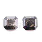 Emerald cut lab grown salt and pepper diamond with geometric step cut facets featuring bold black and smoky inclusions, octagonal shape, ethical sustainable gemstone.