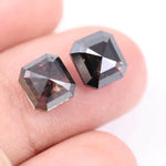 Emerald cut lab grown salt and pepper diamond with geometric step cut facets featuring bold black and smoky inclusions, octagonal shape, ethical sustainable gemstone.
