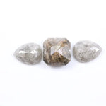 Three natural salt and pepper diamonds featuring two pear rose cut stones and one octagon step cut center diamond with visible inclusions and raw earthy tones, ideal for bespoke engagement ring or artisan jewelry design.