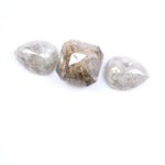 Three natural salt and pepper diamonds featuring two pear rose cut stones and one octagon step cut center diamond with visible inclusions and raw earthy tones, ideal for bespoke engagement ring or artisan jewelry design.