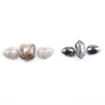 Assorted natural salt and pepper and white rustic diamonds in pear, hexagon, and elongated geometric cuts displayed on a white background, featuring visible inclusions and raw organic patterns.