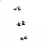 Six natural black diamonds in geometric cuts including star, kite, emerald rectangle, pentagon, and round brilliant shapes displayed on white background.