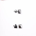 Six natural black diamonds in geometric cuts including star, kite, emerald rectangle, pentagon, and round brilliant shapes displayed on white background.