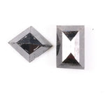 Pair of natural black diamonds featuring a shield-shaped cut and an elongated baguette-style cut, loose matching set with faceted surfaces for custom fine jewelry design.