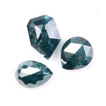 Three natural teal blue diamonds featuring pear, oval, and shield cuts with visible galaxy-like inclusions, rare salt and pepper natural diamonds ideal for custom jewelry design