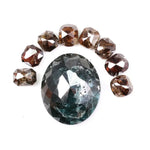 Large natural green diamond surrounded by fancy cognac brown natural diamonds arranged in a semicircle, showcasing rare earth-mined colored diamonds with visible natural inclusions and unique faceting.