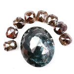 Large natural green diamond surrounded by fancy cognac brown natural diamonds arranged in a semicircle, showcasing rare earth-mined colored diamonds with visible natural inclusions and unique faceting.