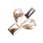 Natural brown salt and pepper diamond set featuring two pear shaped diamonds and two baguette step cut diamonds with visible natural inclusions and rustic champagne tones for custom jewelry design.