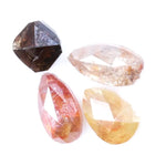 Collection of natural fancy color diamonds including pink, yellow, champagne and cognac loose diamonds with faceted cuts displayed on white background for fine jewelry and gemstone collecting.