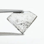 Shield cut lab grown diamond with clear body and natural-looking black inclusions in a salt and pepper pattern, faceted loose gemstone for custom jewelry