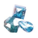 Collection of natural blue diamonds in unique geometric cuts including triangular, hexagon, and pear shapes with vivid ocean-blue tones and natural inclusions on a white background.