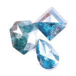 Collection of natural blue diamonds in unique geometric cuts including triangular, hexagon, and pear shapes with vivid ocean-blue tones and natural inclusions on a white background.
