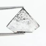 Shield cut lab grown diamond with clear body and natural-looking black inclusions in a salt and pepper pattern, faceted loose gemstone for custom jewelry