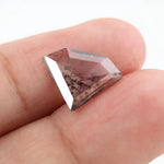 Shield cut lab grown diamond with clear body and natural-looking black inclusions in a salt and pepper pattern, faceted loose gemstone for custom jewelry