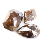 Three natural brown diamonds with unique cuts and facets, showcasing a rich, earthy hue and natural inclusions, perfect for fine jewelry or collectors.