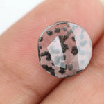 Round faceted lab grown diamond with distinctive black inclusions creating a salt and pepper effect inside a clear polished gemstone