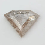 Close-up of a faceted lab grown diamond with visible natural-style inclusions, brilliant cut geometry, and soft champagne hue on a clean white background