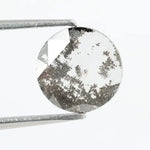 Round faceted lab grown diamond with distinctive salt and pepper style inclusions creating a galaxy-like pattern, showcasing a unique and modern alternative to traditional clear diamonds