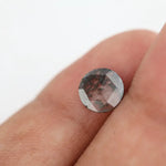 Round faceted lab grown diamond with distinctive salt and pepper style inclusions creating a galaxy-like pattern, showcasing a unique and modern alternative to traditional clear diamonds