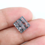 Clear lab-grown diamond with striking black natural-style inclusions inside a polished rectangular crystal, showcasing a unique modern gemstone aesthetic