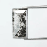 Rectangular step cut lab grown diamond featuring bold black salt and pepper inclusions with mirror-like facets and a modern geometric shape