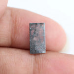 Rectangular step cut lab grown diamond featuring bold black salt and pepper inclusions with mirror-like facets and a modern geometric shape