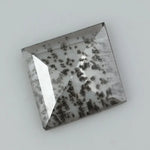 Square step-cut lab grown diamond with dramatic black salt and pepper inclusions, showcasing a unique geometric faceted structure and modern ethical gemstone design