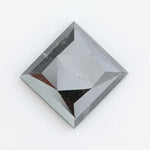 Close-up of a square princess cut black lab-grown diamond with precise facets, reflecting light, showcasing ethical and sustainable luxury gemstone quality.