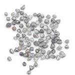 grey black natural diamond with a rugged raw surface and uncut profile