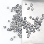 grey black natural diamond with a rugged raw surface and uncut profile