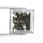 Sqaure step cut salt and pepper lab grown diamond with galaxy-like black and white inclusions, featuring a geometric faceted shape and transparent edges, ideal for unique engagement rings or custom jewelry designs