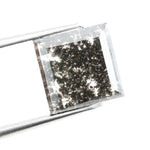 Sqaure step cut salt and pepper lab grown diamond with galaxy-like black and white inclusions, featuring a geometric faceted shape and transparent edges, ideal for unique engagement rings or custom jewelry designs