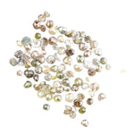 Natural multi colour rough diamonds with yellow, grey, champagne and white tones displayed on white background.