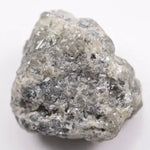 A close-up view of a grey diamond showcasing its unique salt-and-pepper appearance with visible mineral inclusions.