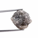 A side view of a grey diamond engagement ring, featuring the gem's distinctive speckles and smoky hues, set in platinum.