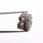 A side view of a grey diamond engagement ring, featuring the gem's distinctive speckles and smoky hues, set in platinum.
