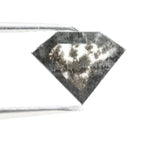 Geometric cut salt and pepper lab grown diamond with smoky black and white inclusions, showcasing a unique faceted shape and modern ethical gemstone design on a clean white background