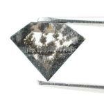 Geometric cut salt and pepper lab grown diamond with smoky black and white inclusions, showcasing a unique faceted shape and modern ethical gemstone design on a clean white background
