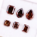 Set of premium brown lab-grown diamonds in emerald, pear, and octagon cuts displaying rich fancy color and brilliant faceting for custom fine jewelry designs.