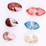 Six fancy color lab grown diamonds on white background including yellow oval cut, blue marquise cut, pink marquise cut, peach pear cut, deep red pear cut, and red oval cut brilliant stones for custom jewelry design.