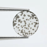 Close-up of a unique lab-grown diamond featuring distinct black carbon inclusions, showcasing its natural beauty and sustainable origins.
