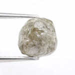 Raw diamond crystal inspected under bright lighting.
