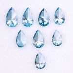 Eight vivid blue pear cut lab grown diamonds displayed on white background, featuring brilliant faceting, teardrop shape, and rich ocean blue tones ideal for custom engagement rings and fine jewelry.