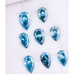 Eight vivid blue pear cut lab grown diamonds displayed on white background, featuring brilliant faceting, teardrop shape, and rich ocean blue tones ideal for custom engagement rings and fine jewelry.