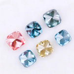 Six cushion cut lab grown diamonds in fancy colors including deep teal, vivid blue, pink, yellow, and light blue displayed on white background for fine jewelry design.