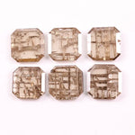 Six emerald cut lab grown diamonds with soft champagne color and visible internal growth pattern inclusions, arranged in two rows and numbered 1 through 6 on a white background.