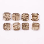 Emerald step cut lab grown diamonds with champagne tone and visible natural-style inclusions arranged in two rows on a white background.
